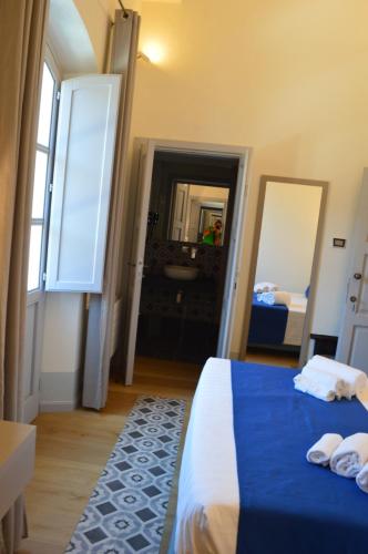 a bedroom with a bed and a bathroom with a mirror at TANIT ROOMS & SPA in Villasimius