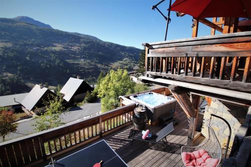bañera de hidromasaje en la cubierta de una casa en Chalet with Ski Slope Views, Jacuzzi & Cinema Room en Vars