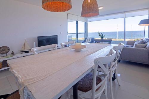 una sala de estar con una gran mesa de madera y sillas en Oceana Suites en Lumiere, frente a playa Mansa en Punta del Este