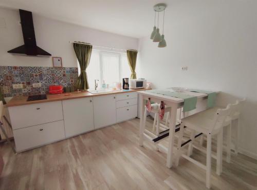 a kitchen with white cabinets and a table and chairs at Cozy Attic Azuga in Azuga