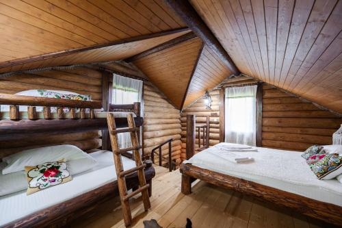 a bedroom with two bunk beds in a log cabin at Cabana din Revier in Vişeu de Jos