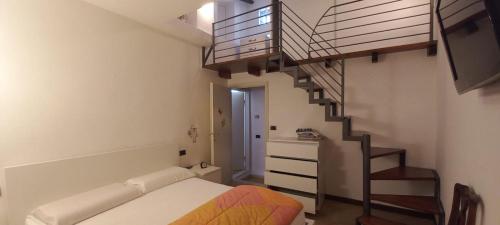 a bedroom with a bed and a spiral staircase at La Casa Gialla in Ortonovo
