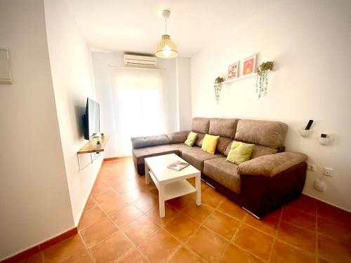 MyChoice Dos Mares by Bossh! Apartments في روتا: غرفة معيشة مع أريكة وطاولة