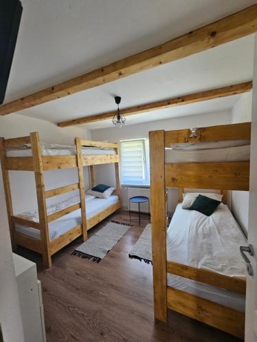 two bunk beds in a room with wooden floors at Casa Denis & Kevin in Petrila
