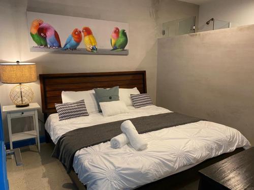 1 dormitorio con 1 cama con loros en la pared en P0 - Walk To The Beach - 4br4br - 1113 Piccioni, en San Juan