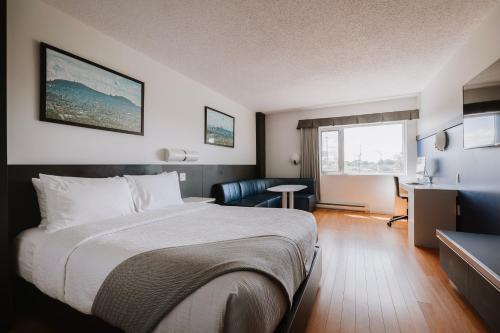 um quarto de hotel com uma cama e uma secretária em Le Dauphin Montréal-Longueuil em Longueuil