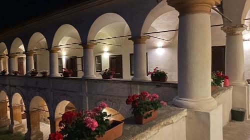 a building with columns and potted plants and flowers at Zámek Ruda nad Moravou in Ruda na Moravě