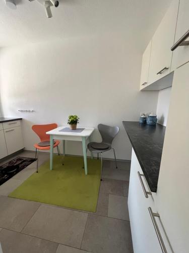 een keuken met een witte tafel en 2 stoelen bij Appartement Seehof in Nassereith
