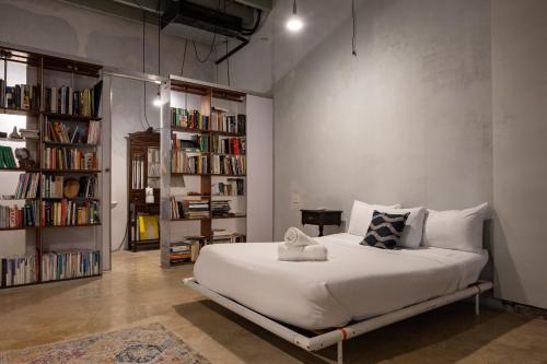 a bedroom with a large white bed and bookshelves at Cozy Studio Gem - Old San Juan - Near Attractions in San Juan