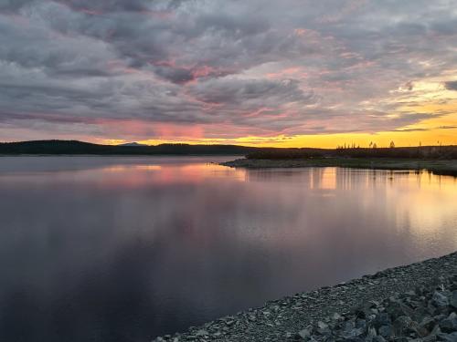 a body of water with a sunset in the background at Camp Dammån in Hallen