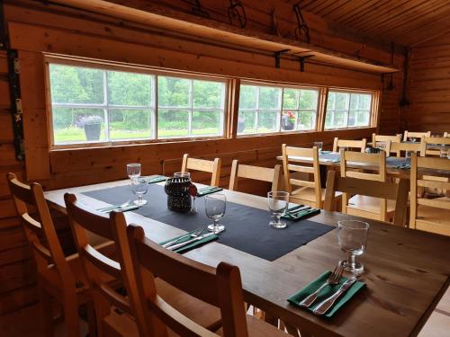 a dining room with a wooden table with wine glasses at Camp Dammån in Hallen