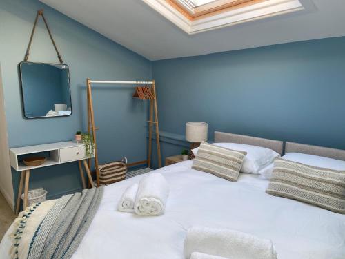 a bedroom with a bed with a tv on the wall at Seaglass Cottage Mumbles in Oystermouth