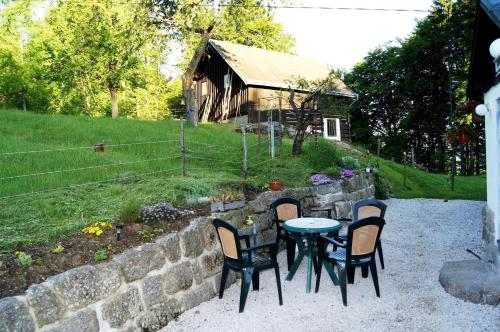 a table and chairs in front of a stone wall at Na Sluneční Pohádková chaloupka ve Sladké díře in Příchovice