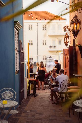 a group of people sitting at a table on a patio at BOHO Bohemian Boutique Hotel in Willemstad