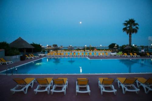 a group of chairs and a swimming pool at night at BT - Le Soleia, confort & lumière, 2 ch, 2 sdb, entre mer et Petite Camargue, super équipé in Lattes