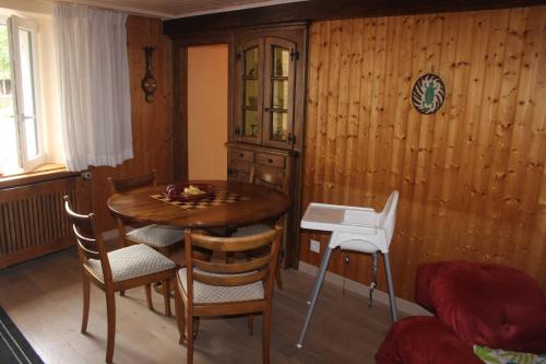 Habitación con mesa, mesa y sillas de madera. en Chez Ginette et Jean-François, en Le Chenit
