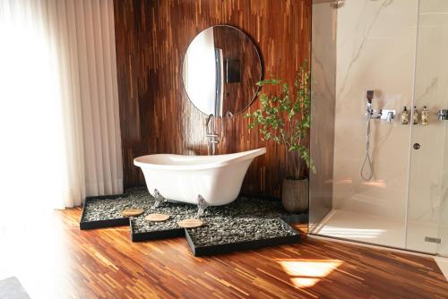 a bathroom with a bath tub and a mirror at Quinta de Silvalde in Santo Tirso