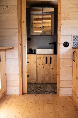 a kitchen with wooden cabinets and a wooden floor at Arboretum in Vlasenice