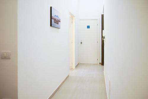 a hallway with white walls and a white door at From Home to Vesuvius - Close to Pompeii, Herculaneum, and the Heart of Naples in Torre del Greco