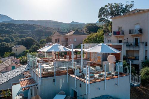 a villa with a swimming pool with umbrellas at HOTEL SAINT ROCH in Ogliastro