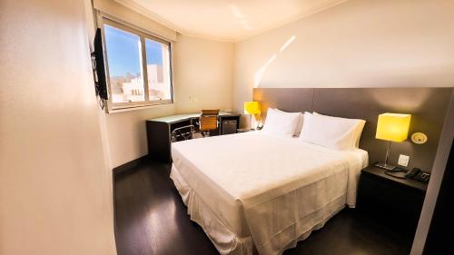 a hotel room with a bed and a window at Hotel Gran Vivenzo Belo Horizonte in Belo Horizonte