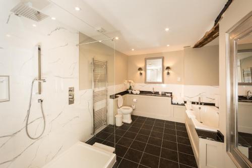 a bathroom with a shower and a toilet and a sink at Hintlesham Hall Hotel in Ipswich