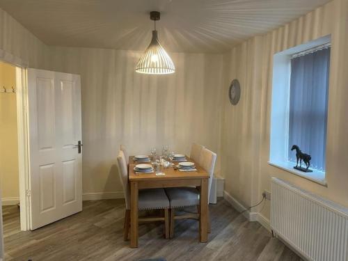 a dining room with a table and a dog in a window at Lovely 2 bedroom apartment in Fleetwood in Fleetwood