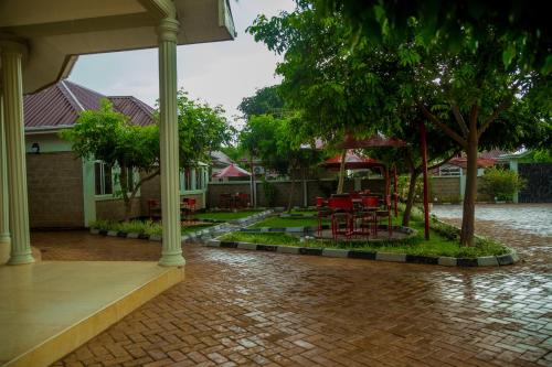 a patio with red chairs and trees in a house at Randa Cottages Moshi in Kirua