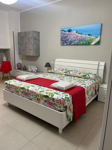 a bedroom with a bed with a red blanket at Le Stanze di Lucia vicino Ospedale Cardinale Panico a Tricase in Tricase