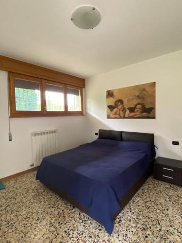 a bedroom with a blue bed and a window at Casa Nostra in Imola