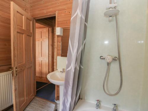 uma casa de banho com um chuveiro e um lavatório. em Elm Lodge em Keswick