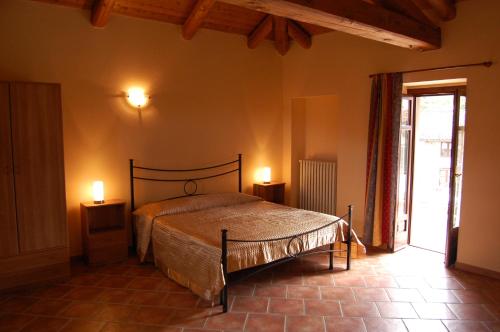 Agriturismo 'd Rainè في Montelupo Albese: غرفة نوم بسرير واضاءتين على طاولتين