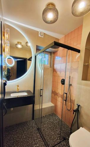 a bathroom with a sink and a shower with a mirror at Dom Wypoczynkowy Oskar Jastrzębia Góra in Jastrzębia Góra