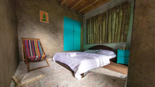 a bedroom with a bed and a chair and blue cabinets at Hillhouse Hunza in Hunza