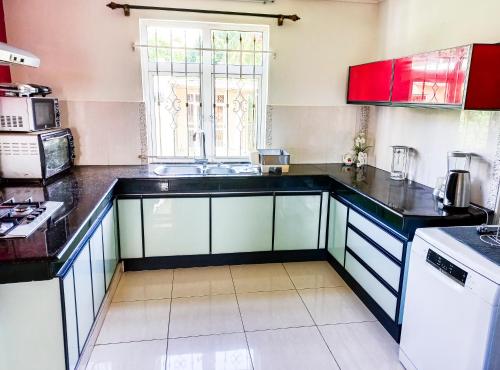 a kitchen with red and blue cabinets and a sink at Residential House 3 Bedroom, 1 Bathroom Entire unit in Beau Bassin in Beau Bassin