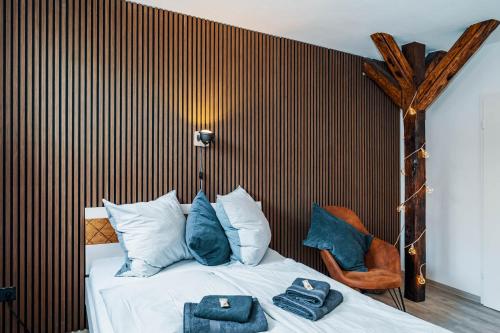 Un dormitorio con una cama con almohadas azules y una silla en Fewo Janks I 11A-N1 I Zentrales Apartment, en Witzenhausen