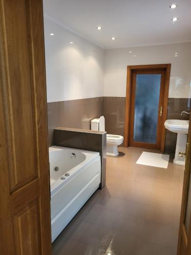 a bathroom with a large tub and a toilet at Sophie's Place in Braşov