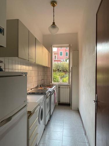 kuchnia z białymi urządzeniami i oknem w obiekcie Appartamento vista mare e uliveto a Tellaro w mieście Tellaro