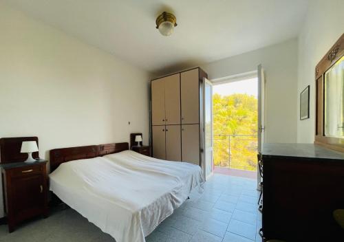 um quarto com uma cama e uma grande janela em Appartamento vista mare e uliveto a Tellaro em Tellaro