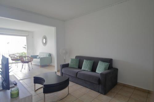 a living room with a couch and a table at Magnifique appt Crystal Beach in Saint-François