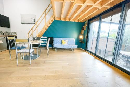 un salon avec une table et des chaises et une cuisine dans l'établissement #DQ Le Drac, à Saint-Égrève