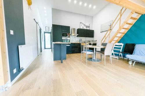 une cuisine et un salon avec une table et des chaises dans l'établissement #DQ Le Drac, à Saint-Égrève