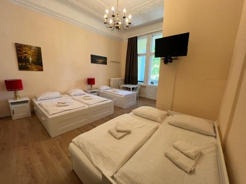 a bedroom with two beds and a flat screen tv at Hotel-Pension Spree in Berlin