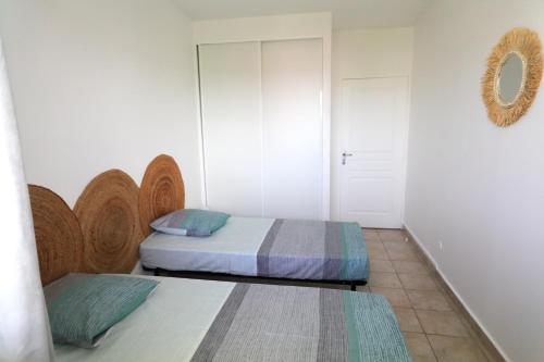1 Schlafzimmer mit 2 Betten und einem Wandspiegel in der Unterkunft Magnifique appt Crystal Beach in Saint-François