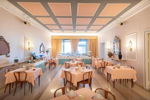 a restaurant with tables and chairs in a room at Hotel Umbra in Assisi