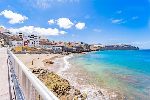 a view of a beach with buildings and the ocean at El Secreto del Norte in Las Palmas de Gran Canaria