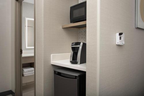 a bathroom with a sink and a tv on a wall at Holiday Inn Express & Suites Knoxville-Clinton by IHG in Clinton