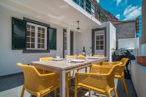 una sala da pranzo con un tavolo e sedie gialle di Casa de Praia no Paul do Mar a Paul do Mar