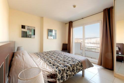 ein Schlafzimmer mit einem Bett und einem großen Fenster in der Unterkunft Maurici Park in Empuriabrava