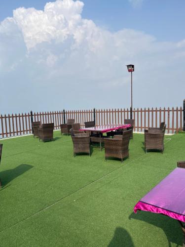 a patio with a table and chairs and a fence at Bhurban Luxury Apartments in Bhurban